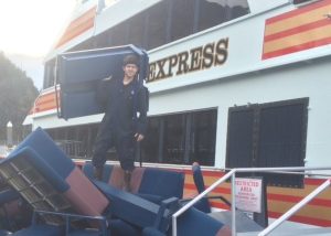 Captain Cody standing on a pile of bench seats removed from the Klondike Express