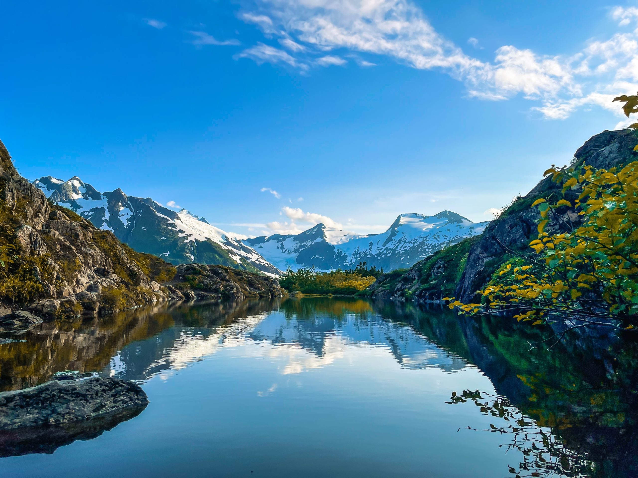 alaskan mountains with body of water in center.